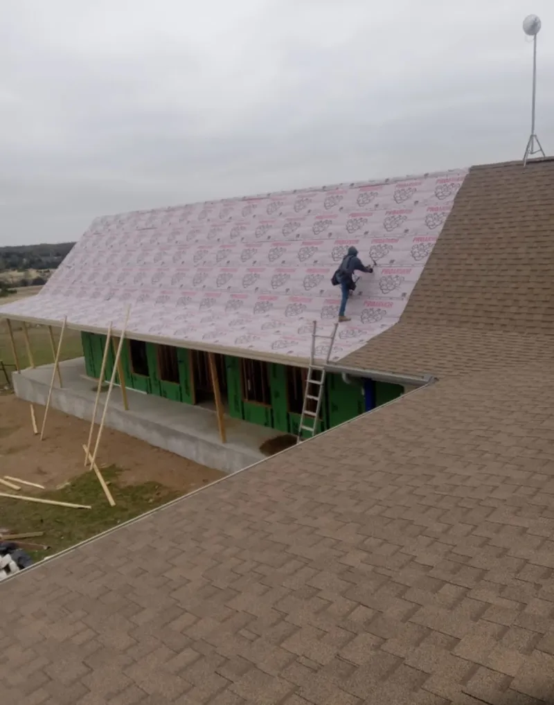 Worker preparing underlayment for a metal roof installation in Murfreesboro